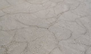 Rissige Betonfläche mit feinen vernetzten Linien